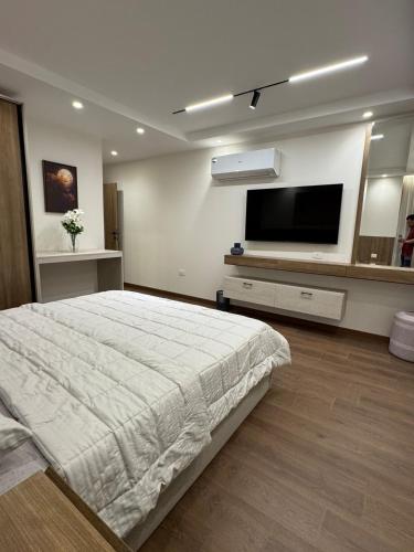 a bedroom with a large bed and a flat screen tv at جناح فندقي بغرفتي نوم 5 نجوم في المهندسين 10b Deluxe Suite in Cairo