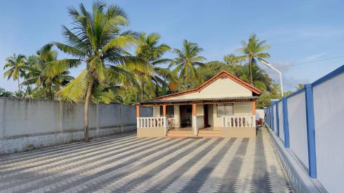 a small house on a roof with a palm tree at Sea Shells by Malpe - Udupi in Cocoanut Island