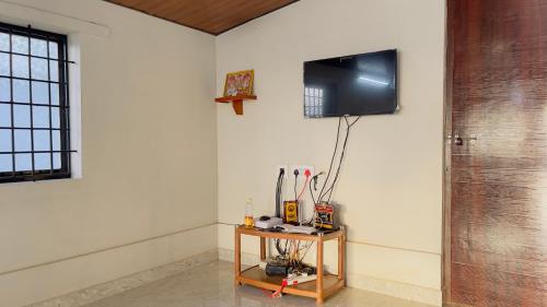 a room with a table with a television on a wall at Sea Shells by Malpe - Udupi in Cocoanut Island