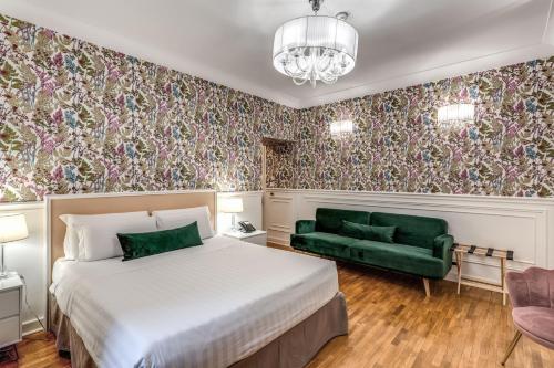a bedroom with a bed and a green couch at Mangili Garden Hotel in Rome