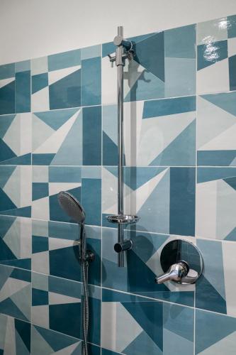 a bathroom with a shower with blue and white tiles at Giano Host - Gozzano, Simple Pleasures in Genova