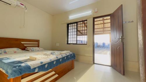 a bedroom with a bed and a sliding glass door at Sea Shells by Malpe - Udupi in Cocoanut Island