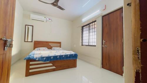 a bedroom with a bed and a open door at Sea Shells by Malpe - Udupi in Cocoanut Island