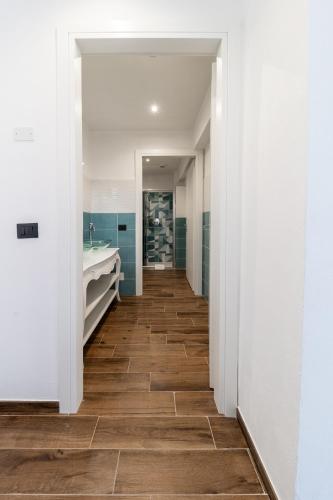 a hallway with a bathroom with a tub and a sink at Giano Host - Gozzano, Simple Pleasures in Genova