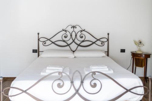 a bed with a metal headboard in a bedroom at Giano Host - Gozzano, Simple Pleasures in Genova