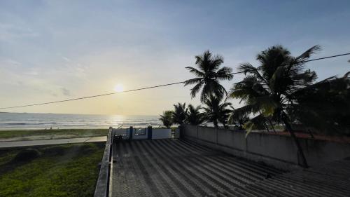 a view of a beach with palm trees and the ocean at Sea Shells by Malpe - Udupi in Cocoanut Island