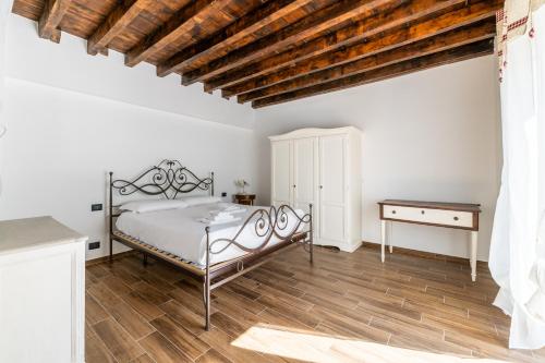 a bedroom with a bed and a wooden floor at Giano Host - Gozzano, Simple Pleasures in Genova