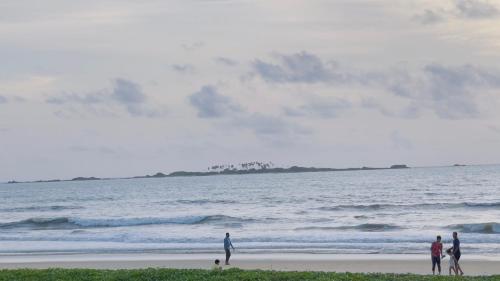 a group of people walking on the beach at Sea Shells by Malpe - Udupi in Cocoanut Island