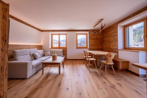 a living room with a couch and a table at Arga' New Alpine Design Apartment Central & Scenic Views in San Vito di Cadore