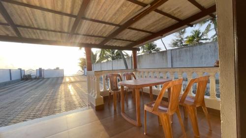 a wooden table and chairs on a balcony at Sea Shells by Malpe - Udupi in Cocoanut Island