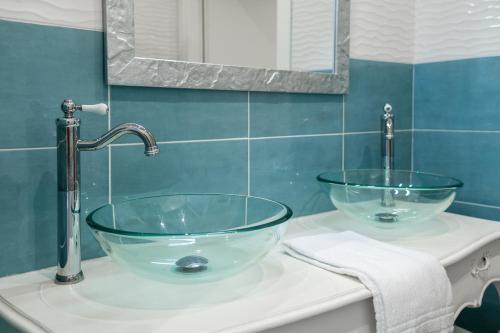 a bathroom with two glass bowls on a sink at Giano Host - Gozzano, Simple Pleasures in Genova