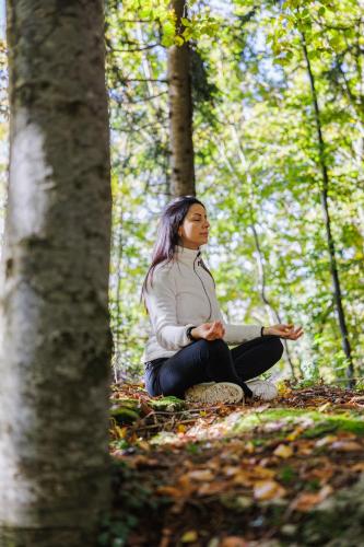a woman sitting on the ground in a forest at Casa Leon d'Oro in Bosco Chiesanuova
