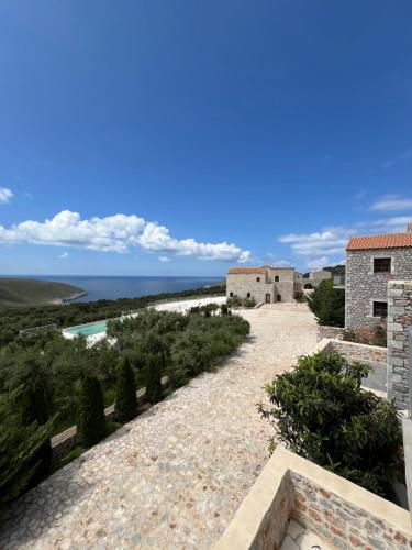 a pathway to a house with the ocean in the background at Koukouri Village in Kafióna