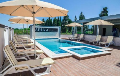 una piscina con sillas y sombrillas en un patio en Aria Apartman 1 Ulcinj, en Ulcinj
