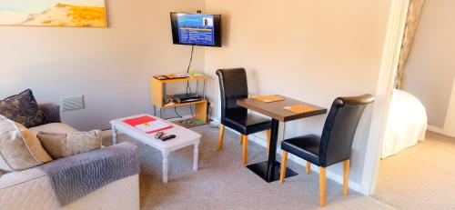 a living room with a table and two chairs at Blue Door Apartment Main St, Carrigart, F92HC04 in Carrigart