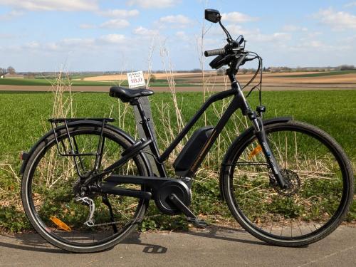 a black bike parked in front of a field at Roulotte Ravel-Emoi Chambre Insolite de Charme in Ramillies