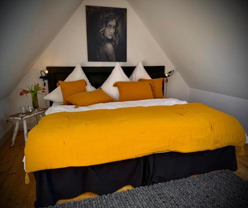 a bedroom with a bed with a yellow blanket at Neu! ULENHUUS Mecklenburgische Schweiz Laage Güstrow Rostock Port Bed and Breakfast - Pension -Ferienhaus - Familienurlaube bis 10 Personen in Kuhs