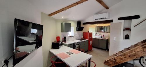 Il comprend une cuisine équipée d'un comptoir blanc et d'un réfrigérateur rouge. dans l'établissement Gîte de village 2p, terrasse de toit et jacuzzi privatif, à Aubignas