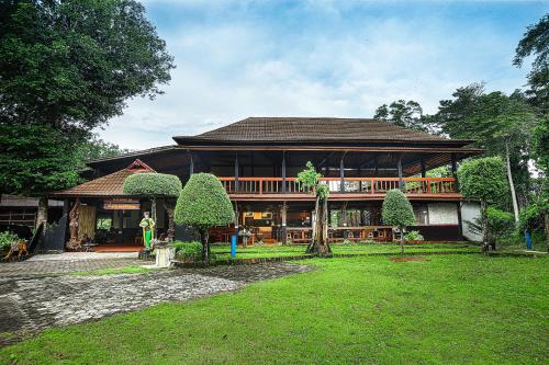 a large house with a large deck in a yard at Plengkung Lodge G-Land in Ringinpintu