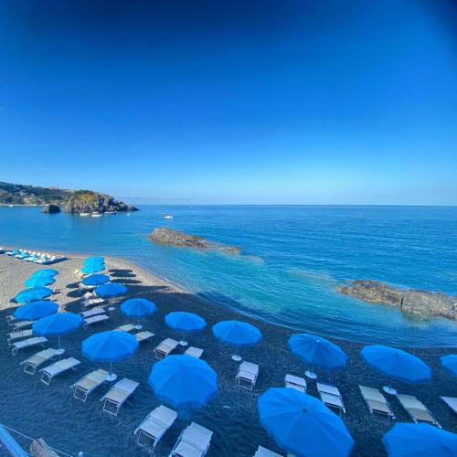 an aerial view of a beach with blue umbrellas at EKOA comfort e relax in San Nicola Arcella
