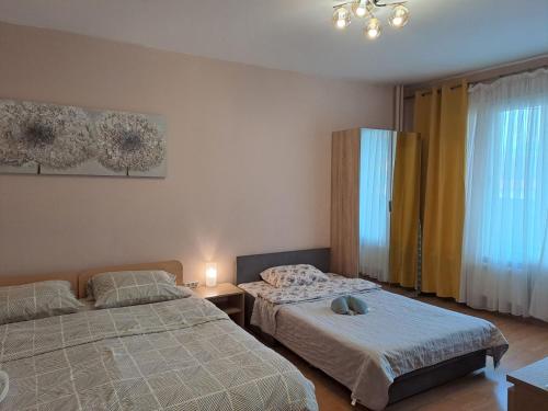 Un dormitorio con dos camas y una ventana. en LevskiG Studio 10 min from Sofia Airport and city centre, en Sofía