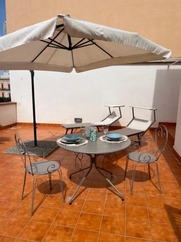 a table and chairs under a large umbrella at La terrazza di nonno Ciccio in Monopoli