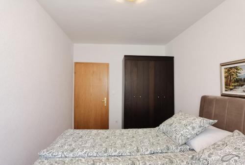 a bedroom with a bed and a brown cabinet at Casa Sol Maris in Novigrad Istria