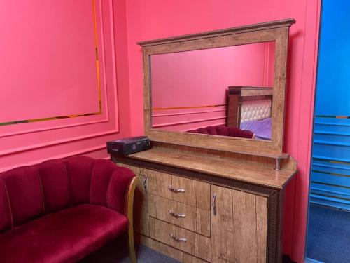 a mirror on top of a dresser with a chair at Yuqori Uy Mexmonxonasi in Kokand