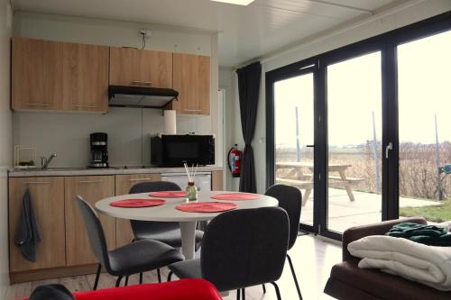 a kitchen and dining room with a table and chairs at Uniek privé natuurdomein voor 14 personen in Evergem