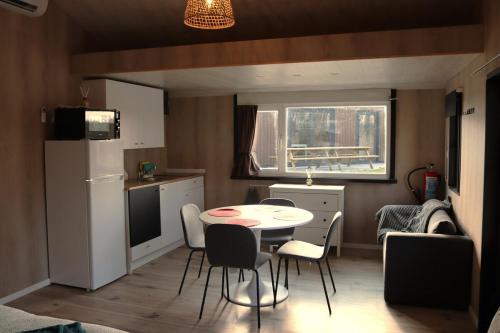 a kitchen with a table and chairs in a small kitchen at Uniek privé natuurdomein voor 14 personen in Evergem