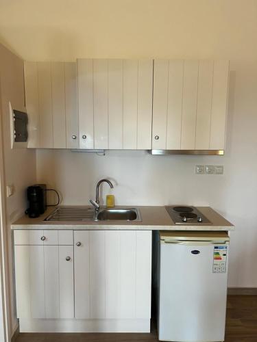 a kitchen with white cabinets and a sink at Koukouri Village in Kafióna
