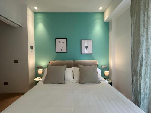 a bedroom with a large bed with a blue wall at Fifty Eight Milan Duomo in Milan