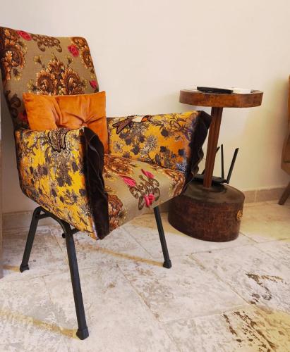 a chair sitting in a room with a side table at Chez Liart 2 in Fasano