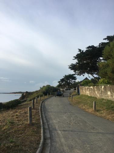 - une voiture circulant sur une route à côté de l'océan dans l'établissement Villa face à la mer avec vue exceptionnelle, à Pénestin