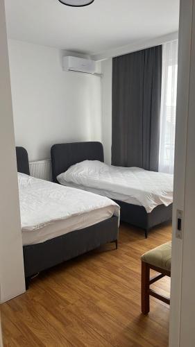 a bedroom with two beds and a chair at Pristina Inn in Prishtinë