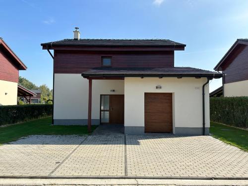 a house with two garage doors and a driveway at Lake house 630 in Šajdíkove Humence