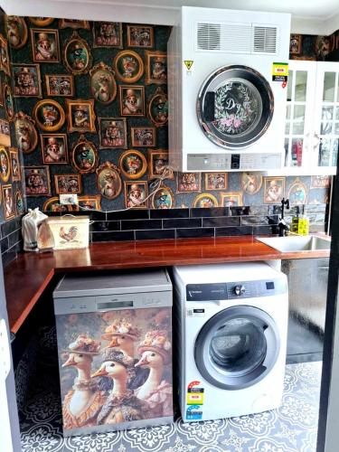 a kitchen with a washing machine and a wall of plates at Bettys Mountain Cottage in York