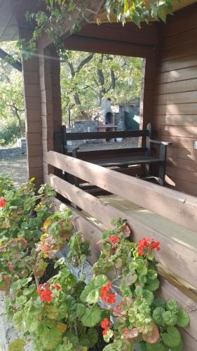 a wooden bench with flowers on a porch at Lo Chalet di Ingrid in Casal Velino