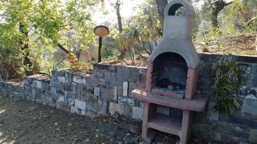 a brick oven sitting next to a stone wall at Lo Chalet di Ingrid in Casal Velino