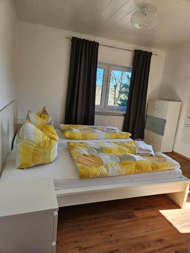 a large bed with yellow blankets and pillows on it at Bokelrehm 4 in Bokelrehm