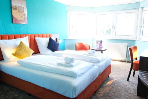 a hotel room with a large bed with towels on it at easy&cosy-Hotel Moers-Mitte in Moers