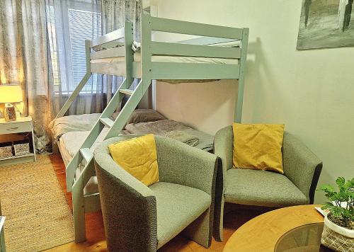a living room with a bunk bed and a chair at Penzión Florens, Nesvady in Nesvady