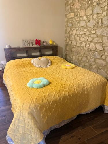 a yellow bed with two towels on top of it at Il Richiamo della Cascata in Papigno