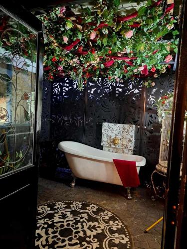 a bathroom with a tub with flowers on the wall at Bettys Mountain Cottage in York