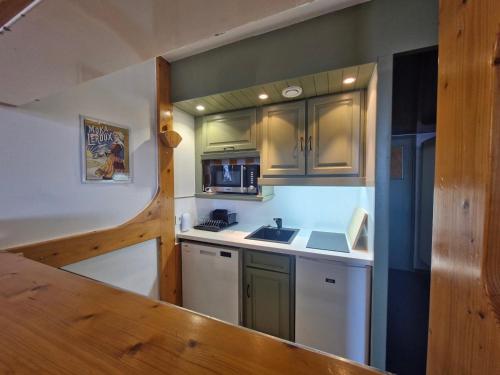 une petite cuisine avec un évier et un micro-ondes dans l'établissement Appartement cosy 2 pièces, 6 personnes, ski-in/ski-out, proche commerces et ESF, balcon sud-ouest - FR-1-411-419, à Arc 1800