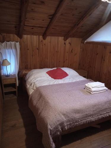 a bedroom with a bed in a wooden cabin at Alma de Puelo in Lago Puelo