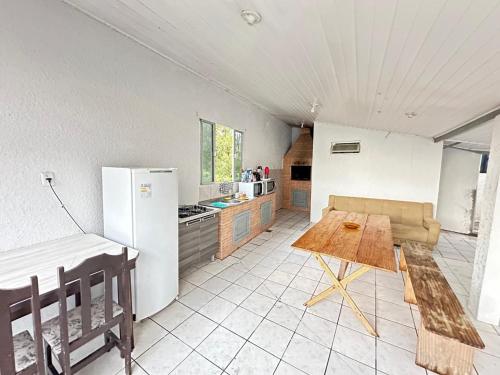 a kitchen with a refrigerator and a table in it at Pousada Dona Zilma Refugio Paradisíaco 2 in Penha