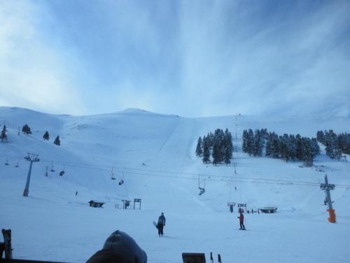 a group of people skiing down a snow covered slope at Faraggi One in Kalavrita