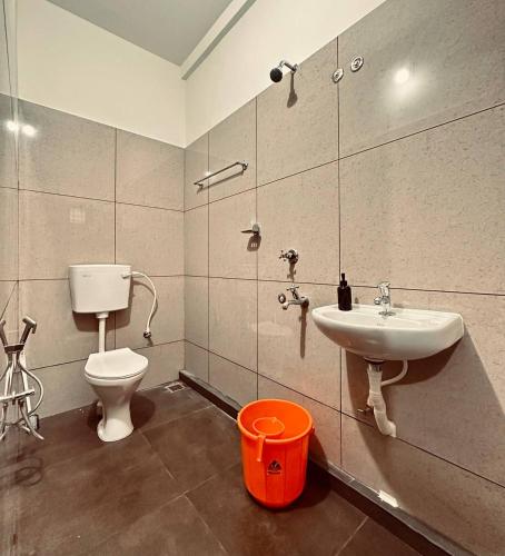 a bathroom with a toilet and a sink at Skye by livNstay in Trivandrum