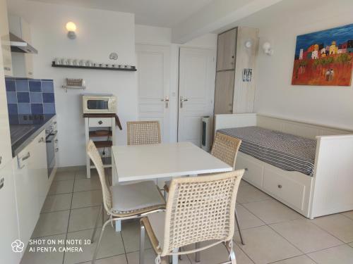 une cuisine et une salle à manger avec une table et des chaises dans l'établissement Soulac Côté Plage - Devant l'océan, à Soulac-sur-Mer